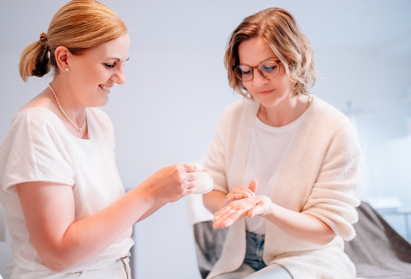 Heike Weigand zeigt einer Kundin eine Pflegecreme