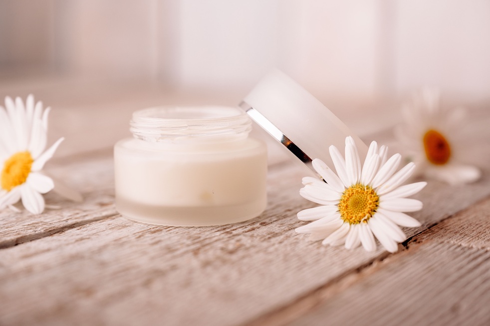 offener Cremetiegel mit Blume