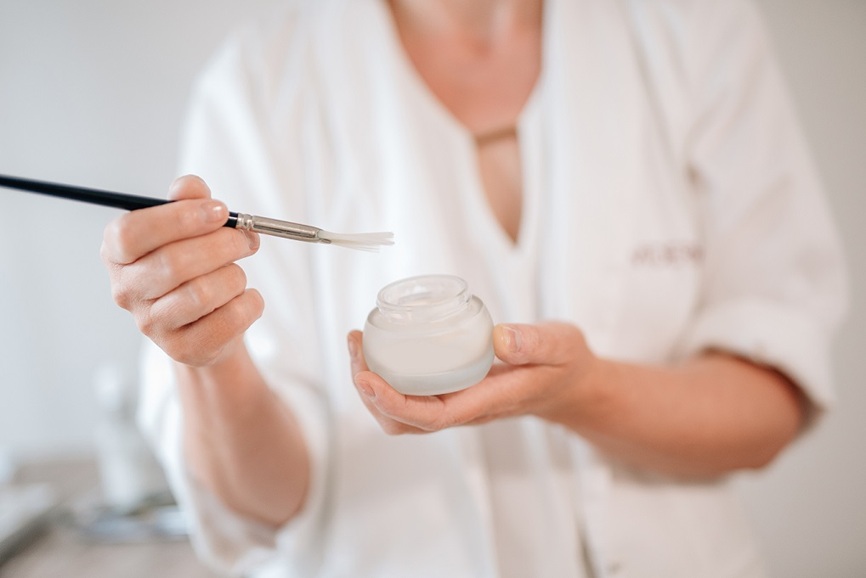 Heike Weigand hat ein Sch&auml;lchen mit Creme und einen Pinsel in der Hand
