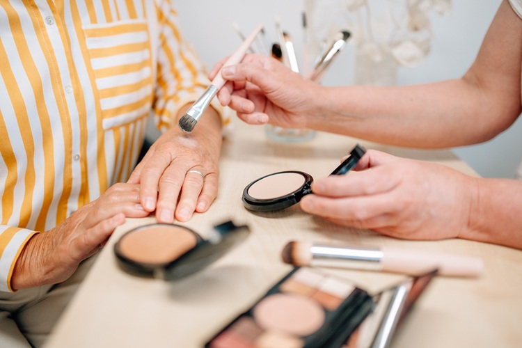 Heike Weigand zeigt einer Kundin Make-up-Produkte