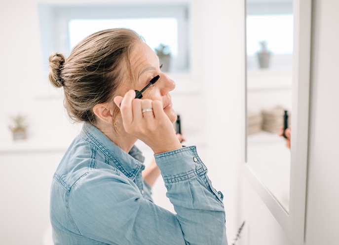 Kundin trägt sich Wimperntusche auf
