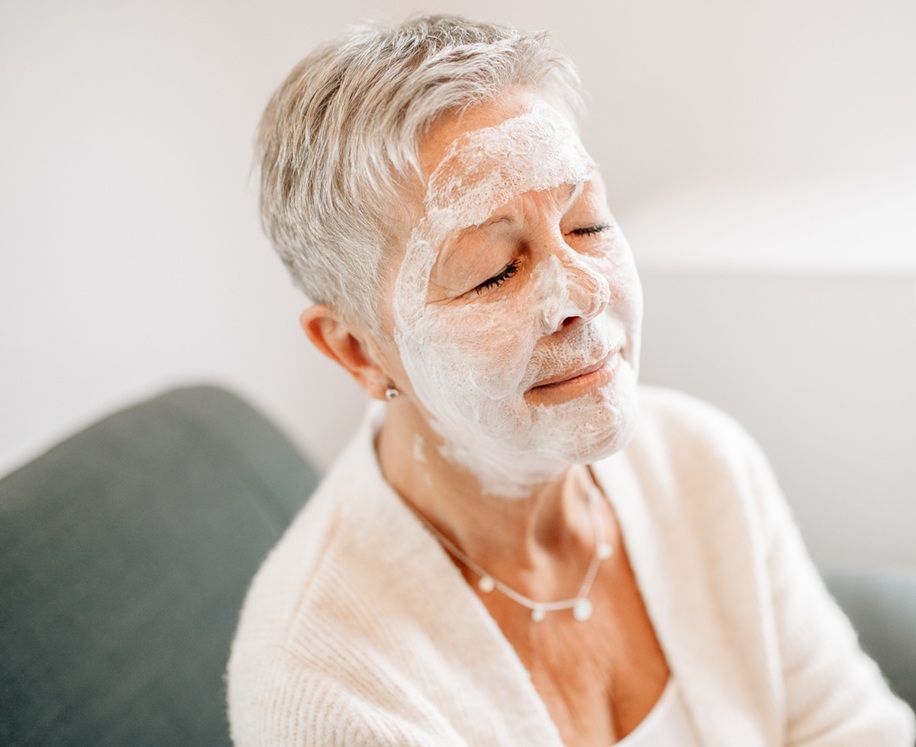 Kundin mit einer Creme-Maske im Gesicht