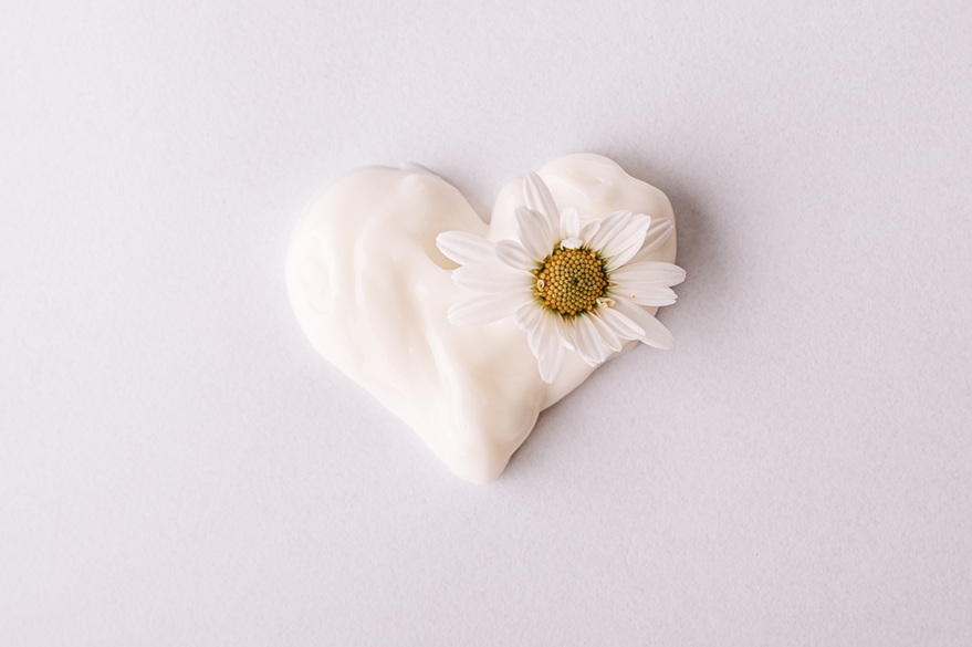 Herz aus Creme mit Gänseblümchen