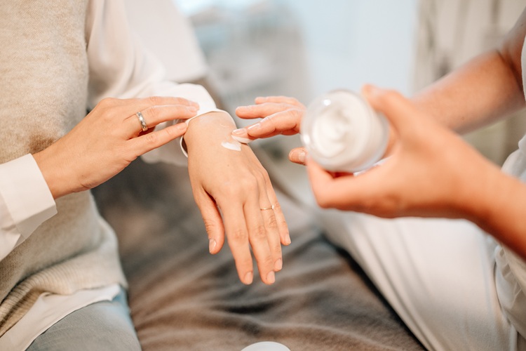  Heike Weigand trägt einer Kundin eine Creme auf die Hand auf