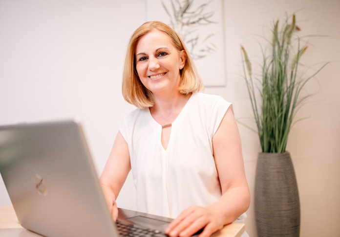 Heike Weigand sitzt am Laptop 