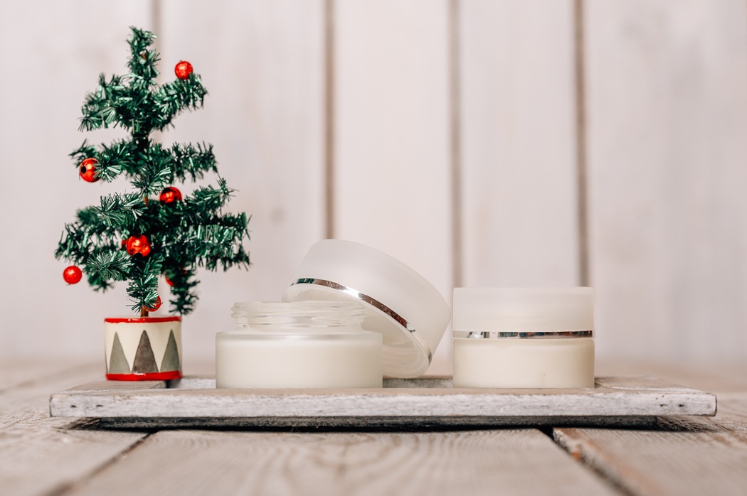 Cremedosen neben kleinem Weihnachtsbaum